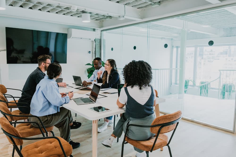 A team meeting in a modern office with a wall-mounted heat pump